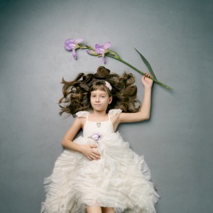 portrét dievčatka vo volánových šatách držiaceho gladiol, pohľad zhora